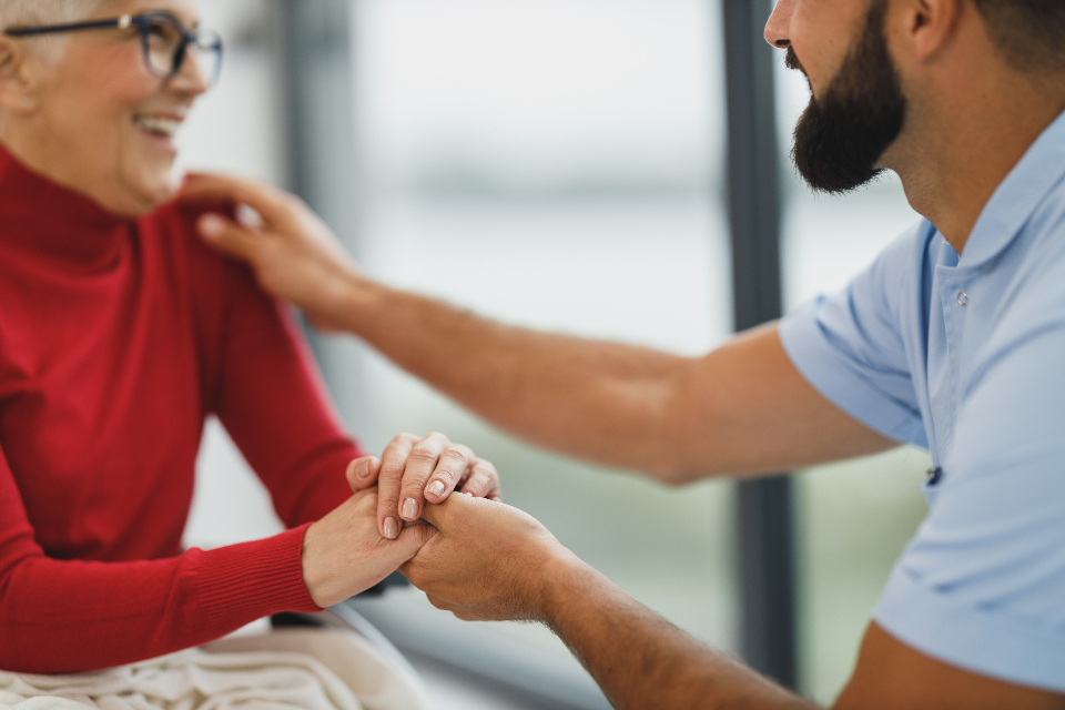 A caregiver gently holding a client's hand